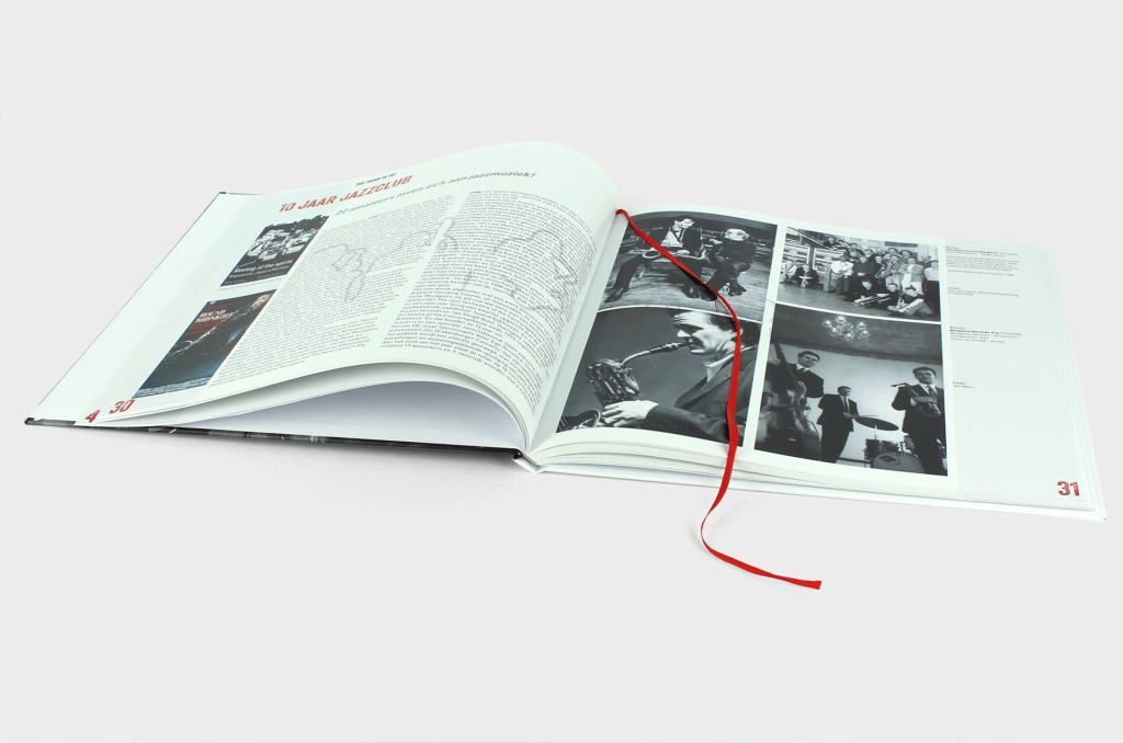 Het binnenwerk van het boek 50 jaar jazz in Artishock met tussen de bladzijden een rood leeslintje.