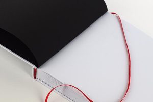 Opengeslagen boek met een rood leeslintje