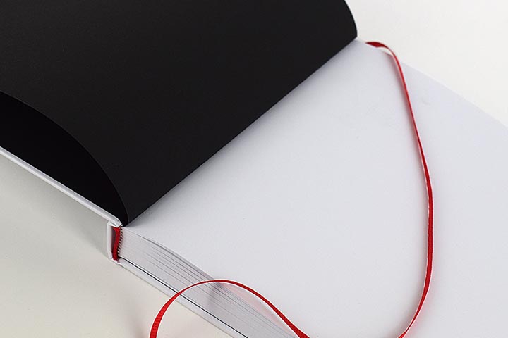 Opengeslagen boek met een rood leeslintje