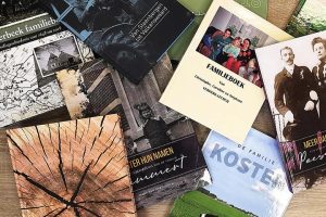 Diverse familieboeken liggen op een tafel.