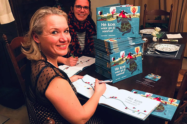 Twee vrouwen signeren het boek Hé koe waar ga jij naartoe?