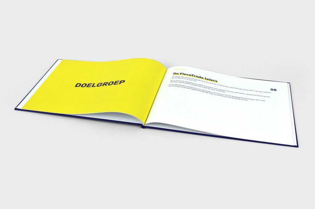 Het boek FlevoTrade opengeslagen op een gele bladzijde met tekst.